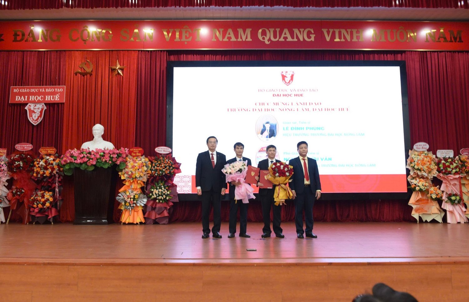 Giám đốc và Phó giám đốc Đại học Huế trao quyết định và tặng hoa chúc mừng Ban Giám hiệu Trường Đại học Nông Lâm. Ảnh: Đại học Huế.