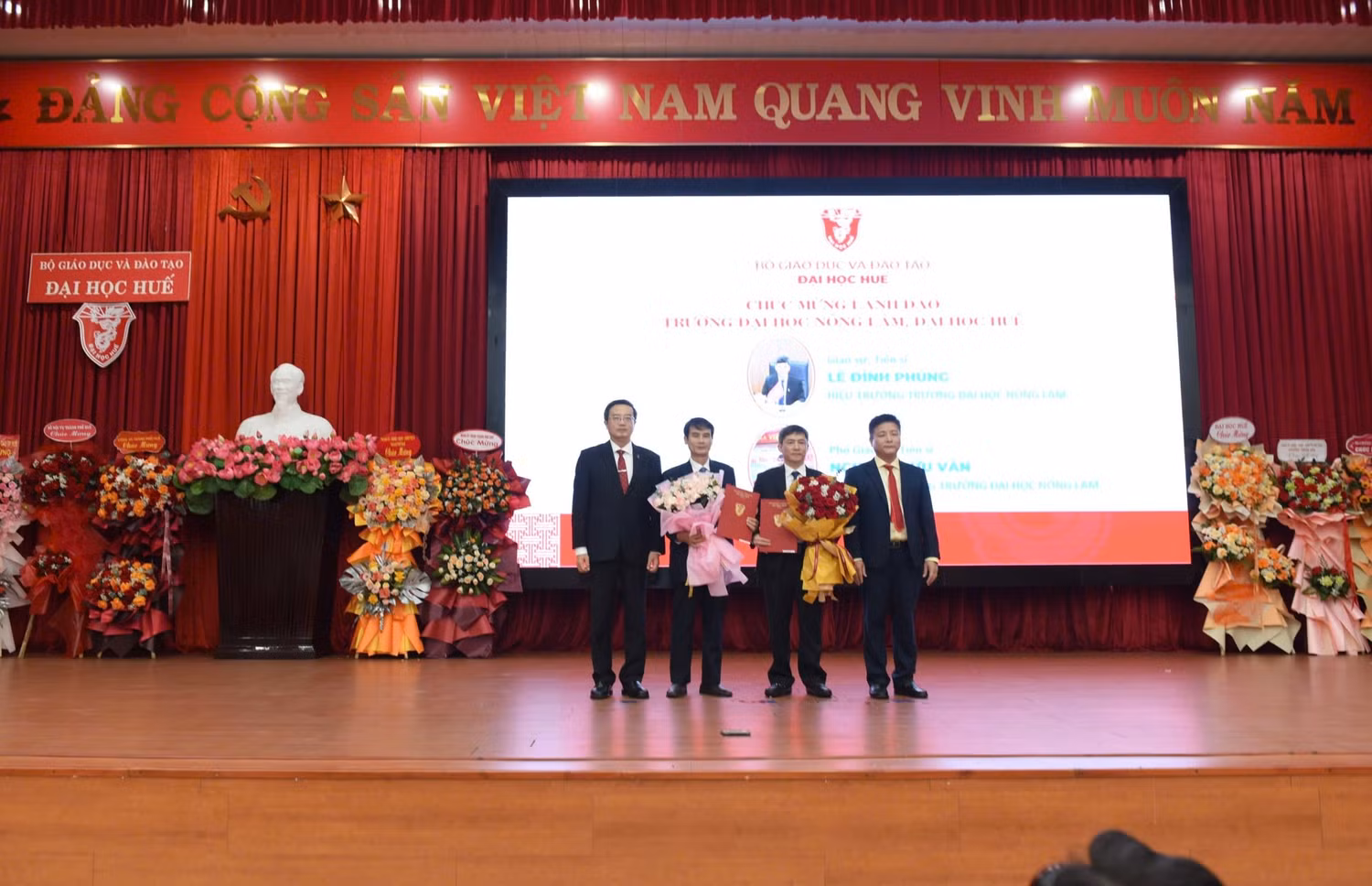 Giám đốc và Phó giám đốc Đại học Huế trao quyết định và tặng hoa chúc mừng Ban Giám hiệu Trường Đại học Nông Lâm. Ảnh: Đại học Huế.