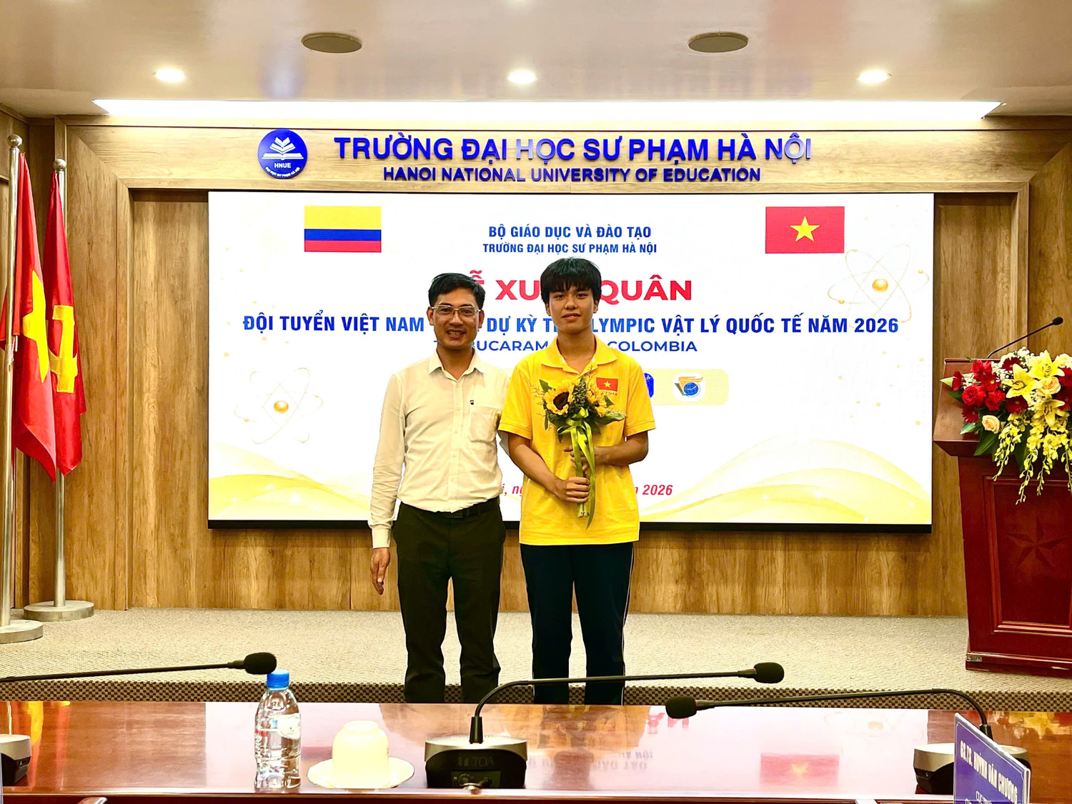 Nhật Minh cùng thầy Nguyễn Công Toản - Phó Hiệu trưởng Trường Trung học phổ thông Chuyên Khoa học Tự nhiên, người đã giảng dạy và truyền niềm yêu thích môn Vật lí cho em, tại Lễ xuất quân Đội tuyển Việt Nam tham dự Kỳ thi Olympic Vật lí quốc tế năm 2026. Ảnh: NVCC