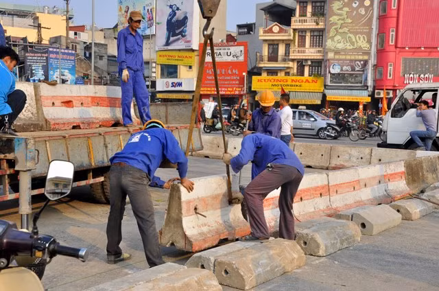 Công nhân gấp rút hoàn thiện những công việc cuối cùng để con đường gọn gàng hơn và nắp các giải phân cách.