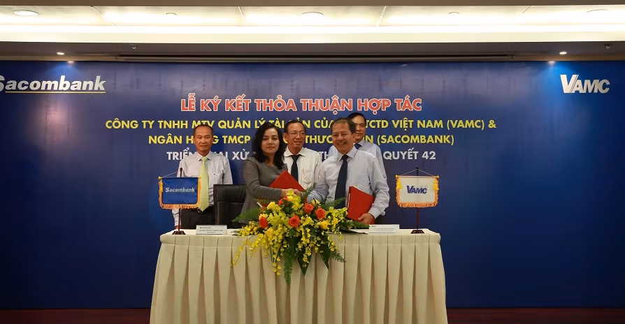 Bà Nguyễn Đức Thạch Diễm – Tổng giám đốc Sacombank và ông Đoàn Văn Thắng – Tổng giám đốc VAMC ký kết thỏa thuận hợp tác với sự chứng kiến của ông Nguyễn Hoàng Minh – Phó giám đốc Ngân hàng Nhà nước Chi nhánh Thành phố Hồ Chí Minh, ông Dương Công Minh – Chủ tịch Hội đồng Quản trị Sacombank và ông Nguyễn Tiến Đông – Chủ tịch Hội đồng Thành viên VAMC.