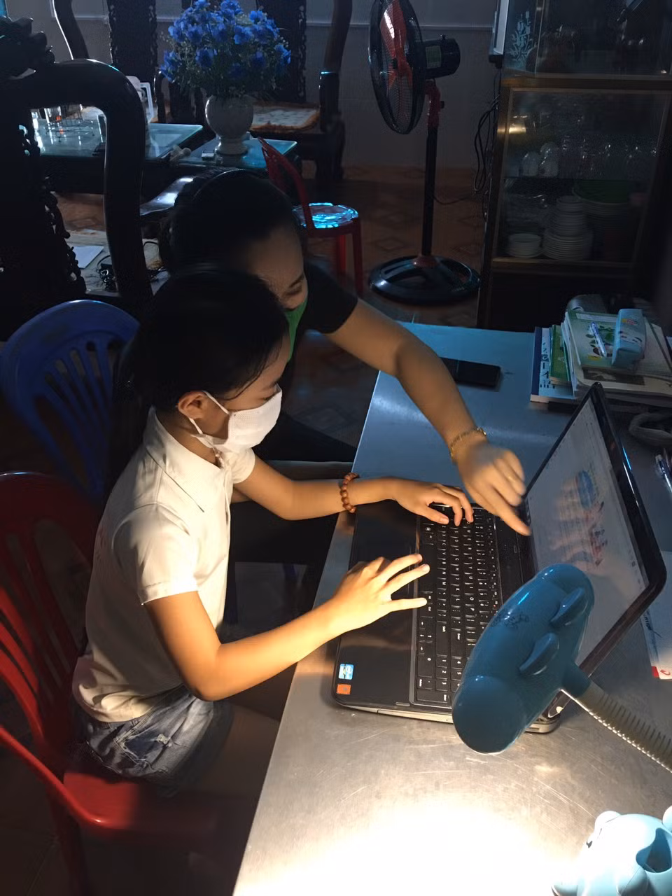 Giáo viên tin học đến tận nhà hướng dẫn học sinh cách sử dụng máy khi vào học trực tuyến (Ảnh nhà trường cung cấp).