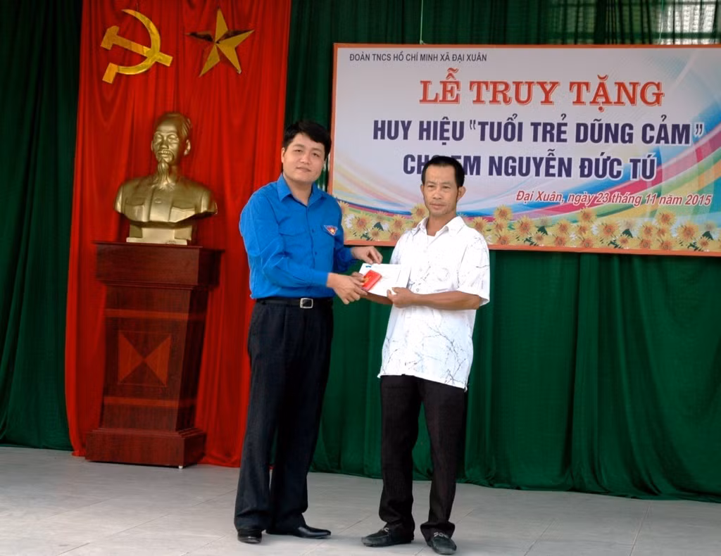 Ông Nguyễn Nhân Chinh (áo xanh) – Phó Bí thư thường trực Tỉnh Đoàn trao Huy hiệu “Tuổi trẻ dũng cảm” do T.Ư Đoàn truy tặng cho đại diện gia đình em Nguyễn Đức Tú năm 2015, ảnh minh họa, nguồn: tinhdoanbacninh.gov.vn.
