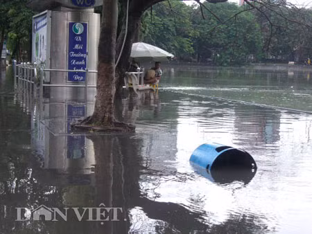Dưới có hồ, còn phía trên lòng đường, vỉa hè cũng lại thành ao sau mưa Nước không thoát kịp xuống cống, ùn ùn đùn nước lên và chảy tràn xuống hồ Gươm Người đàn ông này bị mắc kẹt trên vỉa hè Nước lênh láng cả một đoạn dài phía đường Đinh Tiên Hoàng Có những chỗ ngập sâu đến nửa mét Bãi để xe ô tô ven hồ Gươm cũng bị ngập khá sâu Nước cống hòa nước mưa, ứ đọng, đen ngòm và kèm theo đó là mùi hôi thối nồng nặc Từng mảng váng bẩn cuộn lại theo dòng nước xoáy tràn xuống hồ Gươm Nước bẩn ào ào xối xuống lòng hồ Dưới có hồ, còn phía trên lòng đường, vỉa hè cũng lại thành ao sau mưa Nước không thoát kịp xuống cống, ùn ùn đùn nước lên và chảy tràn xuống hồ Gươm Người đàn ông này bị mắc kẹt trên vỉa hè Nước lênh láng cả một đoạn dài phía đường Đinh Tiên Hoàng Có những chỗ ngập sâu đến nửa mét Bãi để xe ô tô ven hồ Gươm cũng bị ngập khá sâu Nước cống hòa nước mưa, ứ đọng, đen ngòm và kèm theo đó là mùi hôi thối nồng nặc Từng mảng váng bẩn cuộn lại theo dòng nước xoáy tràn xuống hồ Gươm Nước bẩn ào ào xối xuống lòng hồ