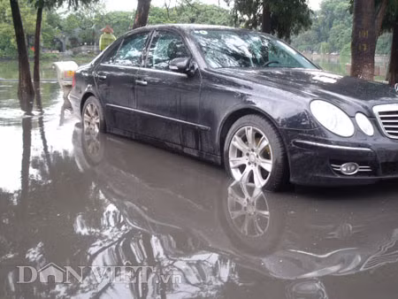 Dưới có hồ, còn phía trên lòng đường, vỉa hè cũng lại thành ao sau mưa Nước không thoát kịp xuống cống, ùn ùn đùn nước lên và chảy tràn xuống hồ Gươm Người đàn ông này bị mắc kẹt trên vỉa hè Nước lênh láng cả một đoạn dài phía đường Đinh Tiên Hoàng Có những chỗ ngập sâu đến nửa mét Bãi để xe ô tô ven hồ Gươm cũng bị ngập khá sâu Nước cống hòa nước mưa, ứ đọng, đen ngòm và kèm theo đó là mùi hôi thối nồng nặc Từng mảng váng bẩn cuộn lại theo dòng nước xoáy tràn xuống hồ Gươm Nước bẩn ào ào xối xuống lòng hồ Dưới có hồ, còn phía trên lòng đường, vỉa hè cũng lại thành ao sau mưa Nước không thoát kịp xuống cống, ùn ùn đùn nước lên và chảy tràn xuống hồ Gươm Người đàn ông này bị mắc kẹt trên vỉa hè Nước lênh láng cả một đoạn dài phía đường Đinh Tiên Hoàng Có những chỗ ngập sâu đến nửa mét Bãi để xe ô tô ven hồ Gươm cũng bị ngập khá sâu Nước cống hòa nước mưa, ứ đọng, đen ngòm và kèm theo đó là mùi hôi thối nồng nặc Từng mảng váng bẩn cuộn lại theo dòng nước xoáy tràn xuống hồ Gươm Nước bẩn ào ào xối xuống lòng hồ