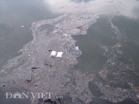 Dưới có hồ, còn phía trên lòng đường, vỉa hè cũng lại thành ao sau mưa Nước không thoát kịp xuống cống, ùn ùn đùn nước lên và chảy tràn xuống hồ Gươm Người đàn ông này bị mắc kẹt trên vỉa hè Nước lênh láng cả một đoạn dài phía đường Đinh Tiên Hoàng Có những chỗ ngập sâu đến nửa mét Bãi để xe ô tô ven hồ Gươm cũng bị ngập khá sâu Nước cống hòa nước mưa, ứ đọng, đen ngòm và kèm theo đó là mùi hôi thối nồng nặc Từng mảng váng bẩn cuộn lại theo dòng nước xoáy tràn xuống hồ Gươm Nước bẩn ào ào xối xuống lòng hồ Dưới có hồ, còn phía trên lòng đường, vỉa hè cũng lại thành ao sau mưa Nước không thoát kịp xuống cống, ùn ùn đùn nước lên và chảy tràn xuống hồ Gươm Người đàn ông này bị mắc kẹt trên vỉa hè Nước lênh láng cả một đoạn dài phía đường Đinh Tiên Hoàng Có những chỗ ngập sâu đến nửa mét Bãi để xe ô tô ven hồ Gươm cũng bị ngập khá sâu Nước cống hòa nước mưa, ứ đọng, đen ngòm và kèm theo đó là mùi hôi thối nồng nặc Từng mảng váng bẩn cuộn lại theo dòng nước xoáy tràn xuống hồ Gươm Nước bẩn ào ào xối xuống lòng hồ
