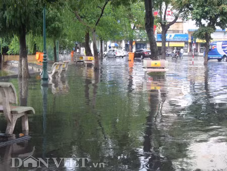 Dưới có hồ, còn phía trên lòng đường, vỉa hè cũng lại thành ao sau mưa Nước không thoát kịp xuống cống, ùn ùn đùn nước lên và chảy tràn xuống hồ Gươm Người đàn ông này bị mắc kẹt trên vỉa hè Nước lênh láng cả một đoạn dài phía đường Đinh Tiên Hoàng Có những chỗ ngập sâu đến nửa mét Bãi để xe ô tô ven hồ Gươm cũng bị ngập khá sâu Nước cống hòa nước mưa, ứ đọng, đen ngòm và kèm theo đó là mùi hôi thối nồng nặc Từng mảng váng bẩn cuộn lại theo dòng nước xoáy tràn xuống hồ Gươm Nước bẩn ào ào xối xuống lòng hồ Dưới có hồ, còn phía trên lòng đường, vỉa hè cũng lại thành ao sau mưa Nước không thoát kịp xuống cống, ùn ùn đùn nước lên và chảy tràn xuống hồ Gươm Người đàn ông này bị mắc kẹt trên vỉa hè Nước lênh láng cả một đoạn dài phía đường Đinh Tiên Hoàng Có những chỗ ngập sâu đến nửa mét Bãi để xe ô tô ven hồ Gươm cũng bị ngập khá sâu Nước cống hòa nước mưa, ứ đọng, đen ngòm và kèm theo đó là mùi hôi thối nồng nặc Từng mảng váng bẩn cuộn lại theo dòng nước xoáy tràn xuống hồ Gươm Nước bẩn ào ào xối xuống lòng hồ