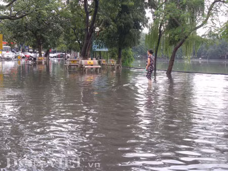 Dưới có hồ, còn phía trên lòng đường, vỉa hè cũng lại thành ao sau mưa Nước không thoát kịp xuống cống, ùn ùn đùn nước lên và chảy tràn xuống hồ Gươm Người đàn ông này bị mắc kẹt trên vỉa hè Nước lênh láng cả một đoạn dài phía đường Đinh Tiên Hoàng Có những chỗ ngập sâu đến nửa mét Bãi để xe ô tô ven hồ Gươm cũng bị ngập khá sâu Nước cống hòa nước mưa, ứ đọng, đen ngòm và kèm theo đó là mùi hôi thối nồng nặc Từng mảng váng bẩn cuộn lại theo dòng nước xoáy tràn xuống hồ Gươm Nước bẩn ào ào xối xuống lòng hồ Dưới có hồ, còn phía trên lòng đường, vỉa hè cũng lại thành ao sau mưa Nước không thoát kịp xuống cống, ùn ùn đùn nước lên và chảy tràn xuống hồ Gươm Người đàn ông này bị mắc kẹt trên vỉa hè Nước lênh láng cả một đoạn dài phía đường Đinh Tiên Hoàng Có những chỗ ngập sâu đến nửa mét Bãi để xe ô tô ven hồ Gươm cũng bị ngập khá sâu Nước cống hòa nước mưa, ứ đọng, đen ngòm và kèm theo đó là mùi hôi thối nồng nặc Từng mảng váng bẩn cuộn lại theo dòng nước xoáy tràn xuống hồ Gươm Nước bẩn ào ào xối xuống lòng hồ
