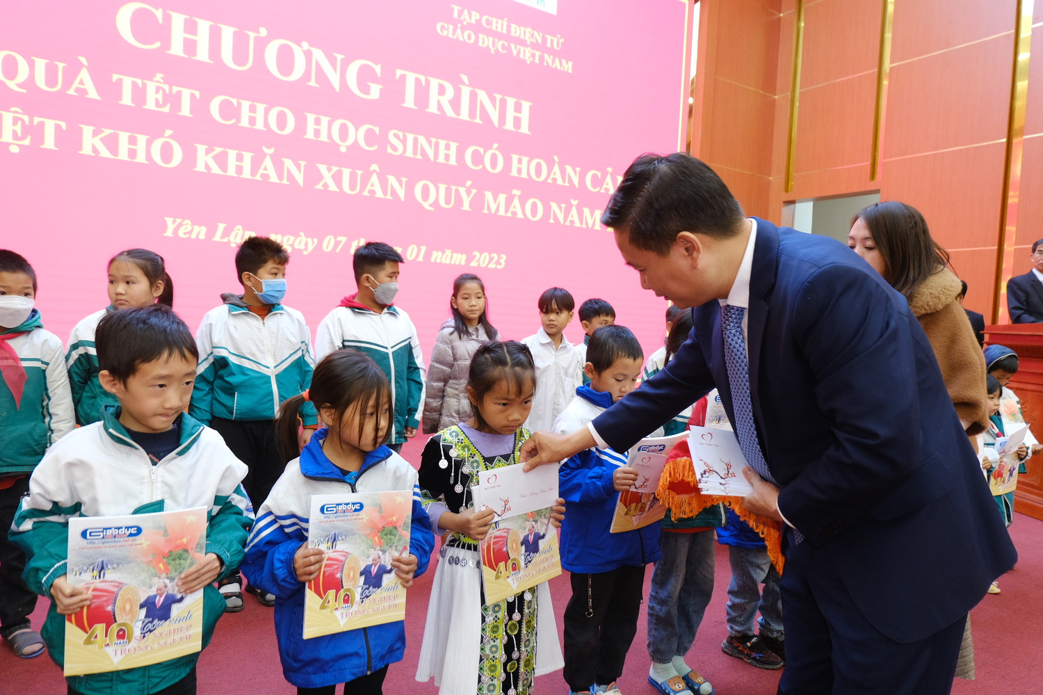Em học sinh người dân tộc Mông được nhận quà từ Tổng Biên tập Nguyễn Tiến Bình.