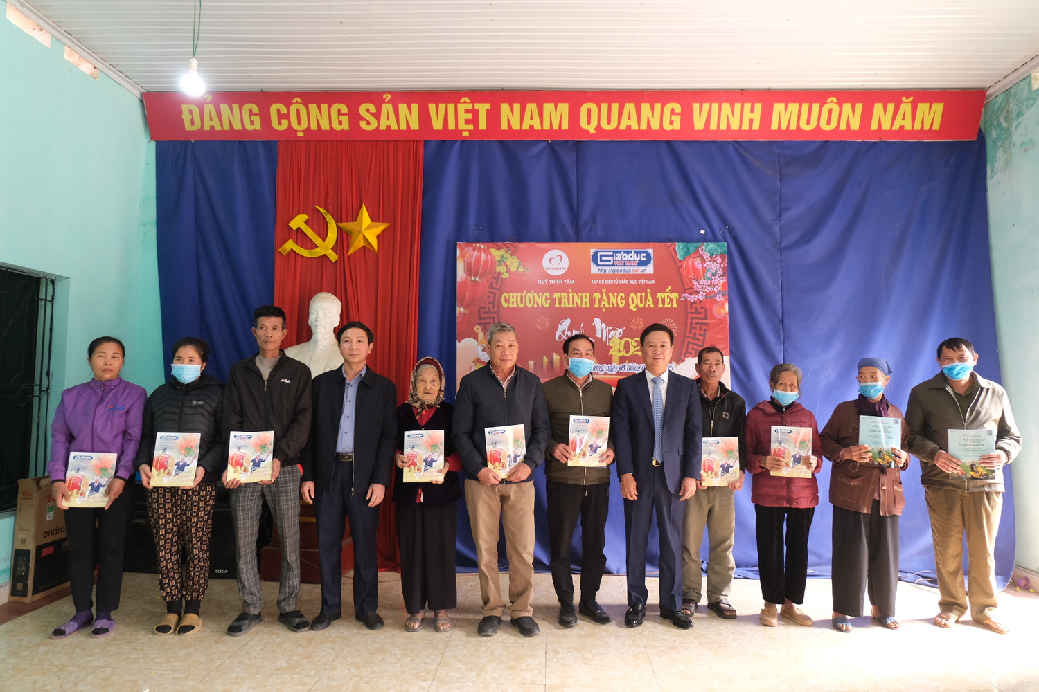 Phó Chủ tịch Hiệp hội Các trường đại học, cao đẳng Việt Nam, Tổng Biên tập Tạp chí điện tử Giáo dục Việt Nam - Nguyễn Tiến Bình cùng lãnh đạo địa phương trao quà tết cho bà con nhân dân xã Hoàng Cương. Ảnh: LC