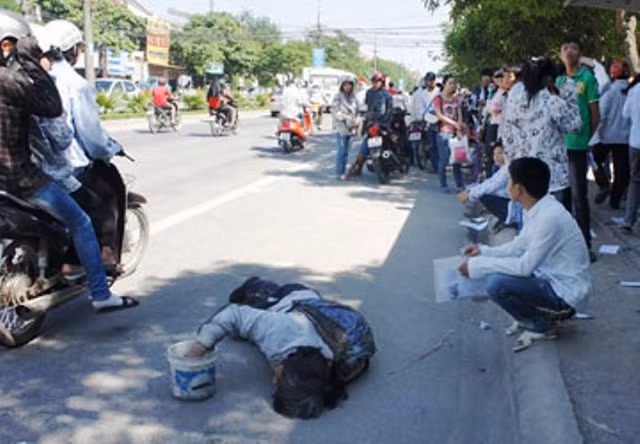 Một đứa bé nằm khóc vật vã xin tiền trước cổng Trường ĐH Vinh để xin tiền. (Ảnh: Đ. Lam) Một đứa bé nằm khóc vật vã xin tiền trước cổng Trường ĐH Vinh để xin tiền. (Ảnh: Đ. Lam)