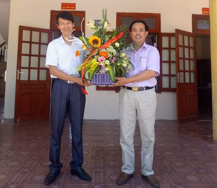 Thầy giáo Đỗ Thế Minh nhận hoa chúc mừng từ Hiệu trưởng Lê Văn Dỵ Ảnh của nhân vật cung cấp.