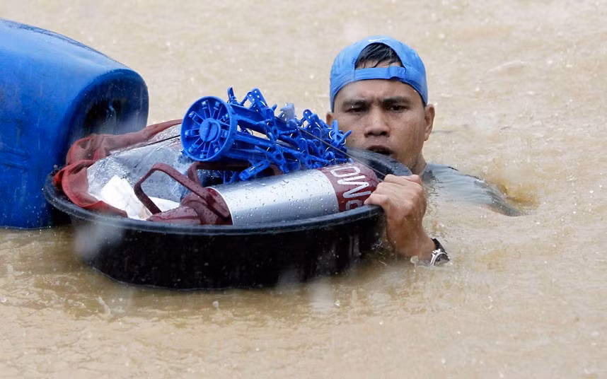 Một người đàn ông mang theo đồ đạc của mình trong khi lội qua một con đường ngập nước ở thành phố Marikina. Một người đàn ông mang theo đồ đạc của mình trong khi lội qua một con đường ngập nước ở thành phố Marikina.