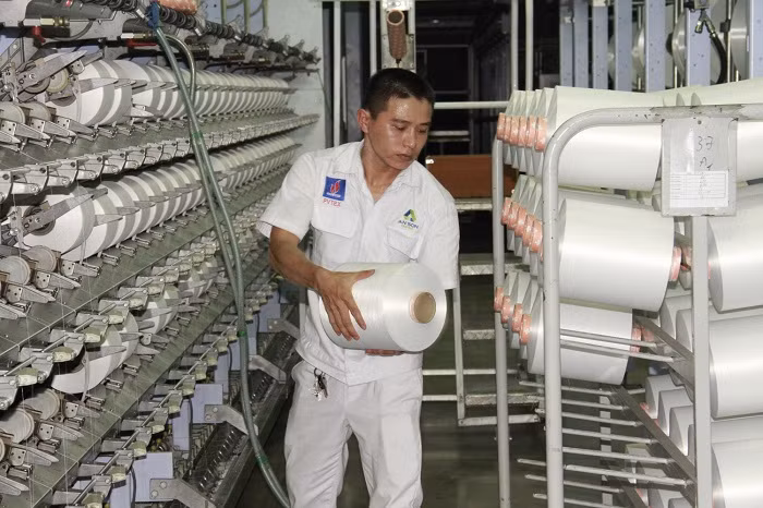Công nhân kỹ thuật xưởng Filament - Nhà máy xơ sợi Đình Vũ đứng máy sản xuất sợi DTY. Công nhân kỹ thuật xưởng Filament - Nhà máy xơ sợi Đình Vũ đứng máy sản xuất sợi DTY.