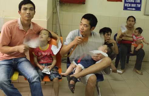 Oi nóng đầu mùa, không khí ngột ngạt do quá đông người, các ông bố không ngưng tay quạt cho con dù hành lang những khu khám đều bố trí khá nhiều quạt. Xem thêm: Những loại quả cực tốt cho sức khỏe / Cách phòng bệnh cho bé.
