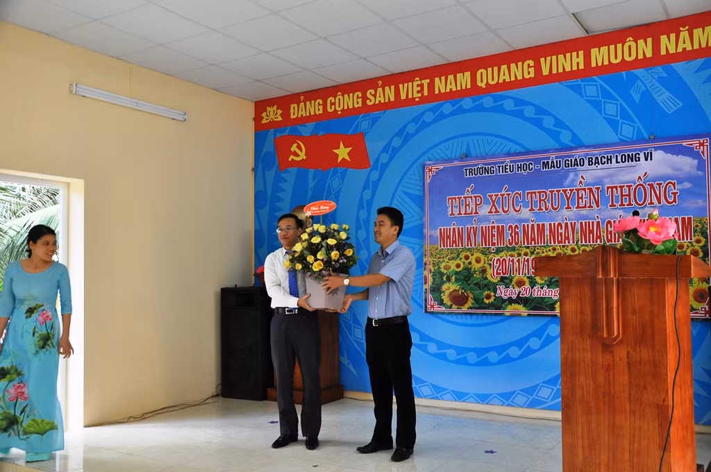 Ông Trần Quang Tường đại diện lãnh đạo huyện đảo tặng hoa chúc mừng nhà trường.