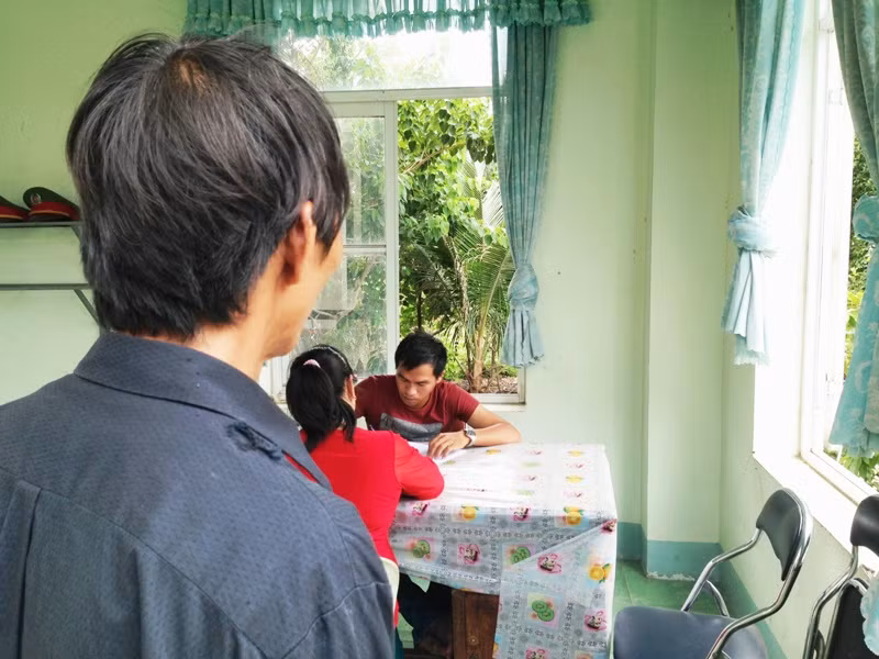 Ông Lê Đình Phú đang nhìn vợ mình làm việc với công an điều tra. Ảnh: Dương Cầm