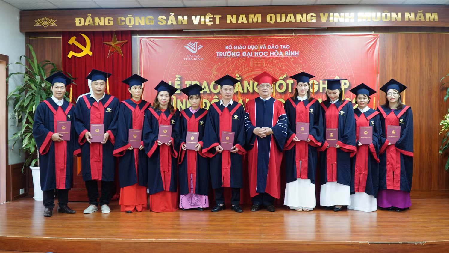 Tiến sĩ Đào Hải và Phó Giáo sư Tô Ngọc Hưng trao bằng khen và bằng tốt nghiệp cho các tân cử nhân, tân kỹ sư. Ảnh: Nguyễn Long