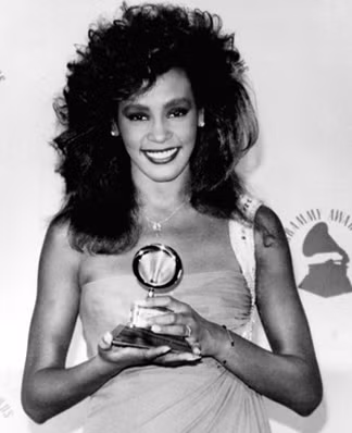 Đây là hình ảnh Whitney chụp cùng tượng Grammy tại lễ trao giải ở Los Angeles vào ngày 26/2/1986. Cô giành giải Nữ ca sĩ trình diễn pop xuất sắc nhất cho ca khúc “Saving all my love for you”. Những hình ảnh này sẽ sống mãi trong lòng những người hâm mộ, những khán giả yêu thích giọng ca bất tử của cô. Và hơn thế nữa, những chiếc váy cô mặc, những bộ trang phục diễn của cô sẽ còn được lưu giữ như một sự tưởng nhớ và luyến tiếc Nữ hoàng nhạc Pop của thế giới này. Ảnh: Xaluan Đây là hình ảnh Whitney chụp cùng tượng Grammy tại lễ trao giải ở Los Angeles vào ngày 26/2/1986. Cô giành giải Nữ ca sĩ trình diễn pop xuất sắc nhất cho ca khúc “Saving all my love for you”. Những hình ảnh này sẽ sống mãi trong lòng những người hâm mộ, những khán giả yêu thích giọng ca bất tử của cô. Và hơn thế nữa, những chiếc váy cô mặc, những bộ trang phục diễn của cô sẽ còn được lưu giữ như một sự tưởng nhớ và luyến tiếc Nữ hoàng nhạc Pop của thế giới này. Ảnh: Xaluan