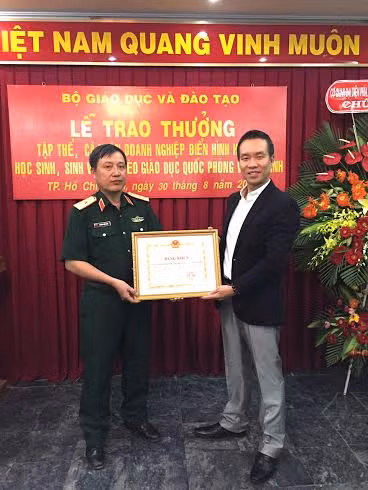 Ông Trương Văn Toàn - đại diện FrieslandCampina Việt Nam (phải) nhận bằng khen của Bộ trưởng Bộ Giáo dục và Đào tạo.