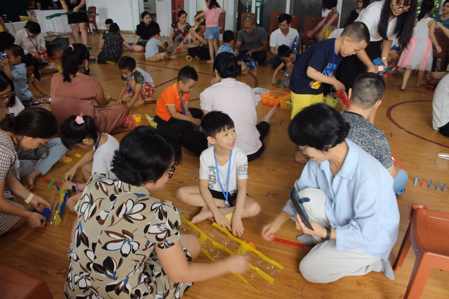 Sau phần đọc cuốn truyện Cầu trượt thật dài, phụ huynh và học sinh cùng làm cầu trượt bằng những chai nhựa đã sử dụng. Ảnh: Vũ Phương.