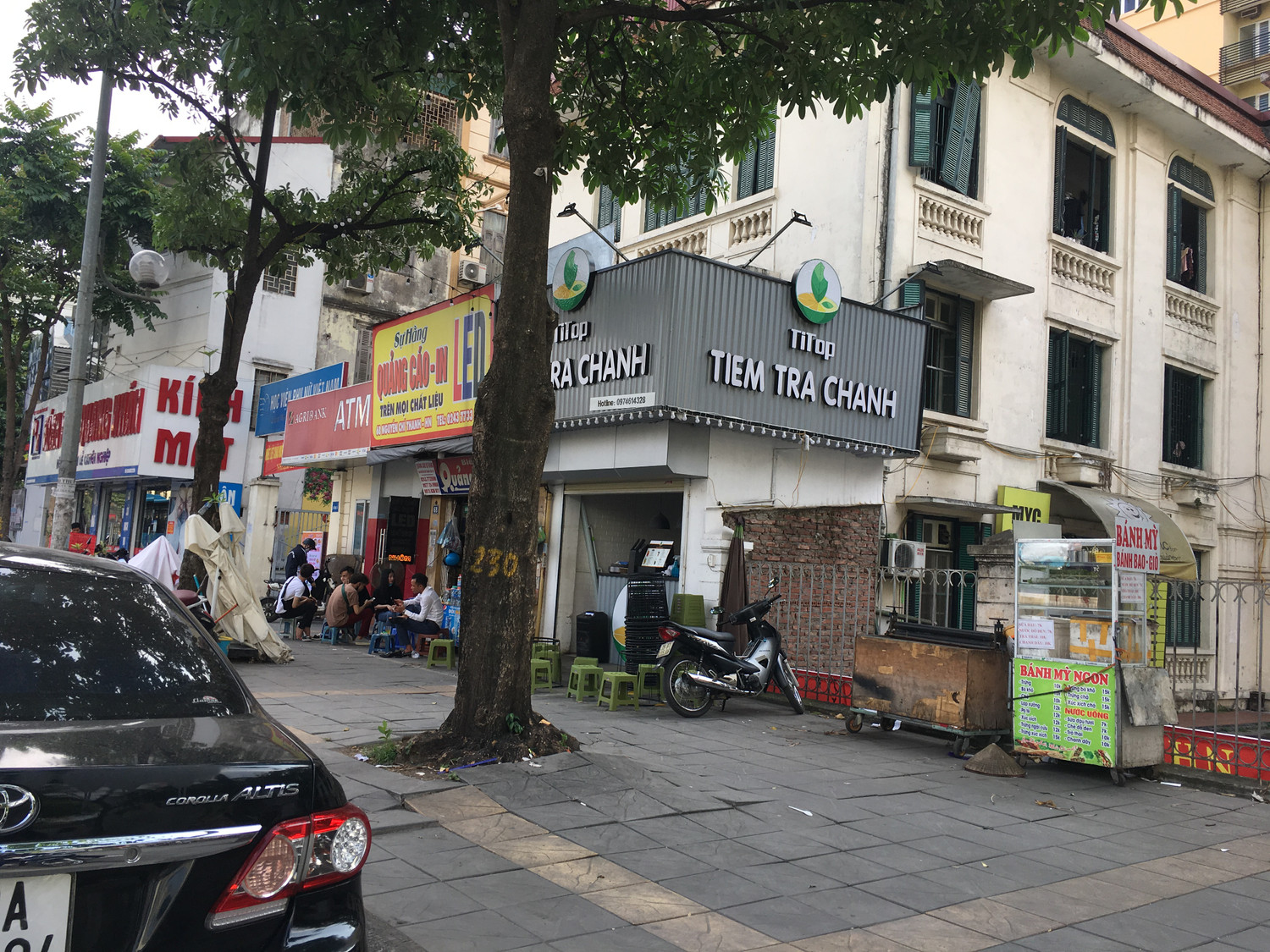 Tiệm trà tranh cơi nới một phần tường chưa trát rất mất thẩm mỹ ngay trong khuôn viên Học viện, xe kéo bán bánh mỳ ngay trước cổng. Ảnh: Vũ Phương.