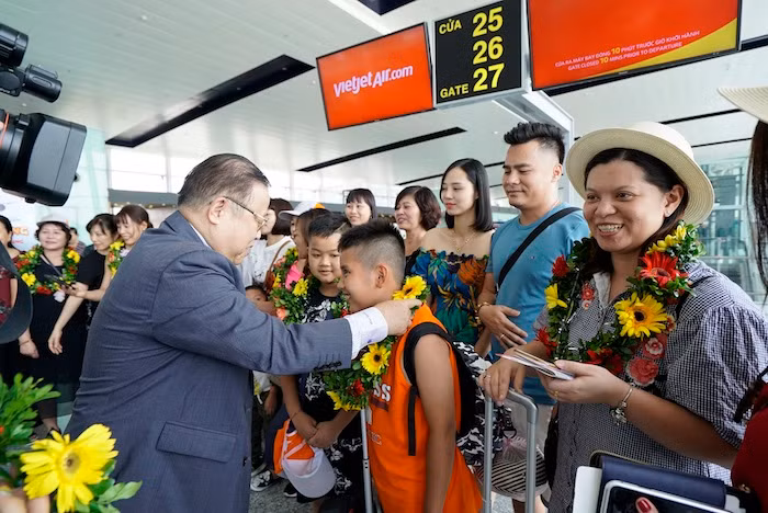 Phó Tổng giám đốc Vietjet Nguyễn Đức Tâm tặng hoa chào đón những hành khách đầu tiên.