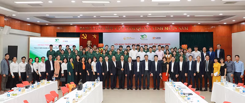 Giáo sư Lê Quân và doanh nhân Đỗ Quang Hiển chụp ảnh lưu niệm với các thế hệ cán bộ giảng viên, sinh viên Đại học Quốc gia Hà Nội