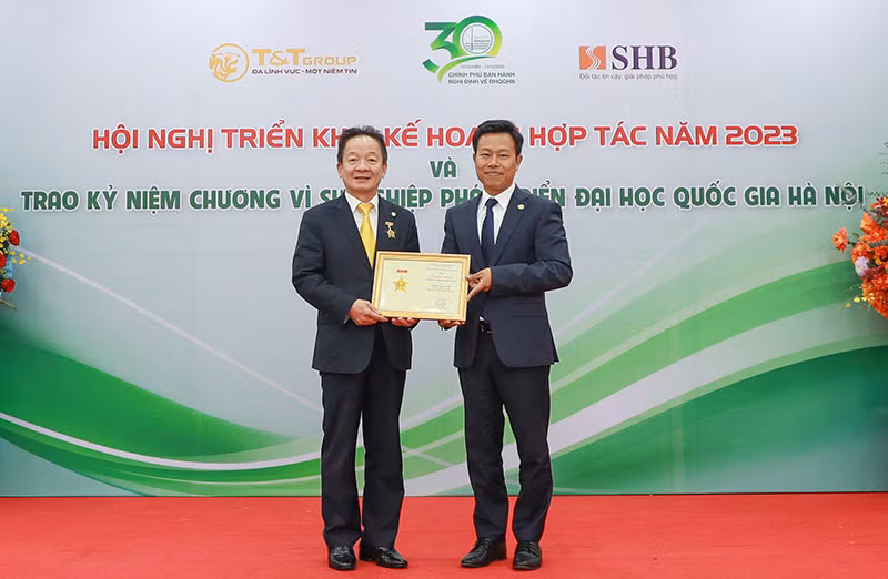 Giáo sư, Tiến sĩ Lê Quân (bên phải) trao kỷ niệm chương vì sự nghiệp phát triển Đại học Quốc gia Hà Nội cho doanh nhân Đỗ Quang Hiển.