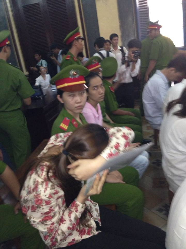 Bị cáo Thiên Kim lẩn tránh ống kính phóng viên. Ảnh: Dương Cầm