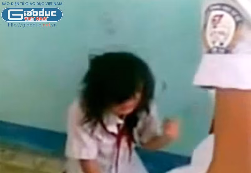 Nữ sinh bị đánh chỉ biết cúi mặt xuống và khóc lóc. >>BẤM ĐÂY XEM CẬP NHẬT ĐIỂM THI ĐẠI HỌC, CAO ĐẲNG NHANH NHẤT 2012