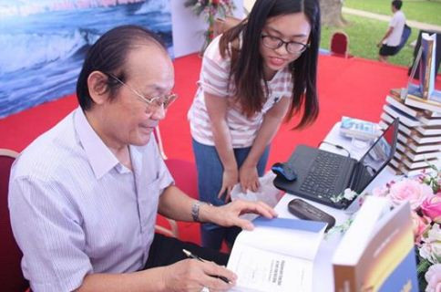 Tiến sĩ Trần Công Trục ký tặng sách bạn đọc trong buổi tọa đàm, ảnh do tác giả cung cấp.