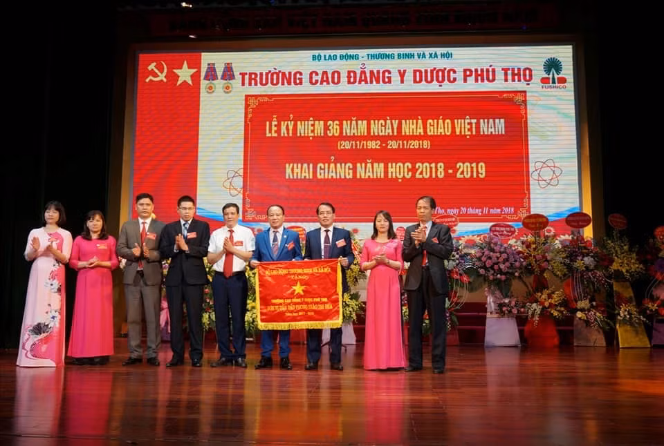 Lãnh đạo nhà trường nhận Cờ thi đua của Bộ Lao động – Thương binh và Xã hội.