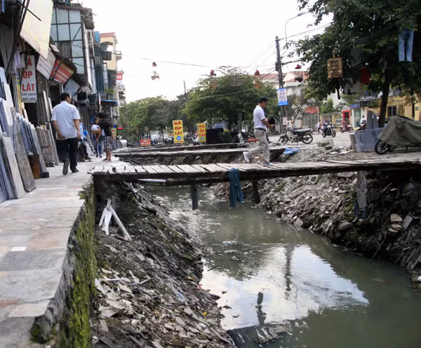 Người lớn có vẻ đơn giản hơn khi băng qua những chiếc cầu ọp ẹp làm tạm bợ để sang bên kia đường Người lớn có vẻ đơn giản hơn khi băng qua những chiếc cầu ọp ẹp làm tạm bợ để sang bên kia đường