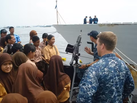 Lính Mỹ giới thiệu về vũ khí trên tàu USS Vandegrift cho các học sinh địa phương. Ảnh: Tnial Lính Mỹ giới thiệu về vũ khí trên tàu USS Vandegrift cho các học sinh địa phương. Ảnh: Tnial
