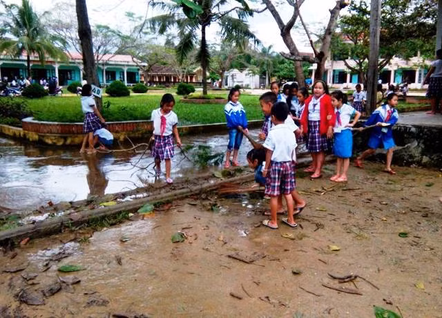 Học sinh trường Tiểu học số 1 Phúc Trạch cùng thầy cô dọn vệ sinh sau lũ (Ảnh: Qúy Hợi)