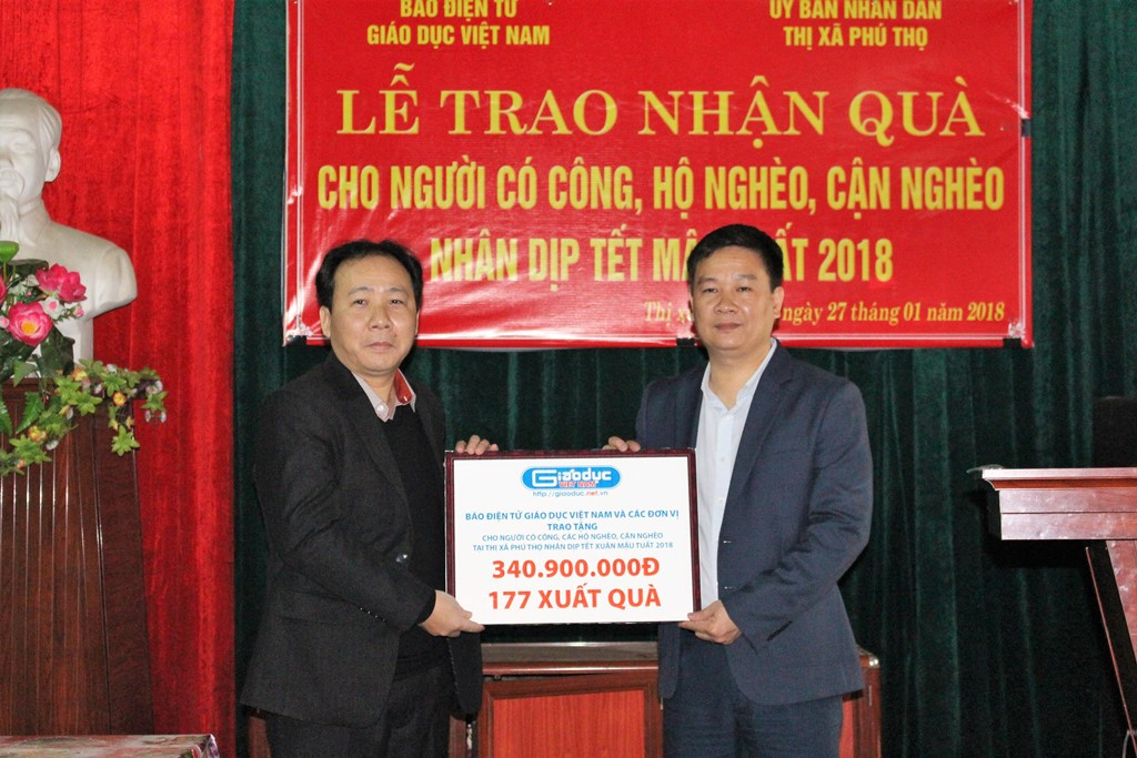 Thay mặt nhân dân địa phương, ông Hà Tuấn Anh, Phó chủ tịch Ủy ban nhân dân thị xã Phú Thọ nhận phần quà từ ông Nguyễn Tiến Bình, Tổng biên tập Báo điện tử Giáo dục Việt Nam (Ảnh: Lại Cường)