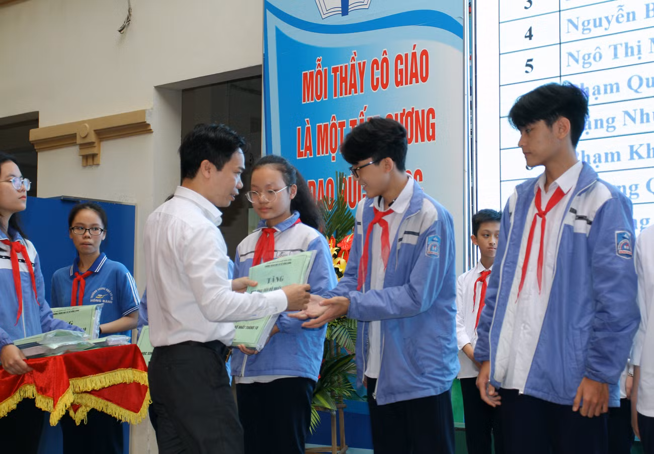 Thầy giáo Trịnh Doãn Toản, Hiệu trưởng Trường Trung học cơ sở Hồng Bàng trao phần thưởng động viên các em học sinh có thành tích xuất sắc trong tháng 10 (ảnh: Lã Tiến)