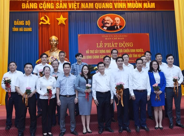 Đồng chí Trương Tấn Sang - nguyên Ủy viên Bộ Chính trị, nguyên Chủ tịch nước (hàng đầu thứ 4 từ phải sang), đồng chí Đặng Quốc Khánh - Ủy viên dự khuyết Ban chấp hành Trung ương Đảng, Bí thư Tỉnh ủy Hà Giang (hàng đầu thứ 4 từ trái sang) chụp ảnh kỷ niệm cùng các đơn vị tài trợ (đại diện Vietcombank đứng hàng 3 thứ 2 từ trái sang).