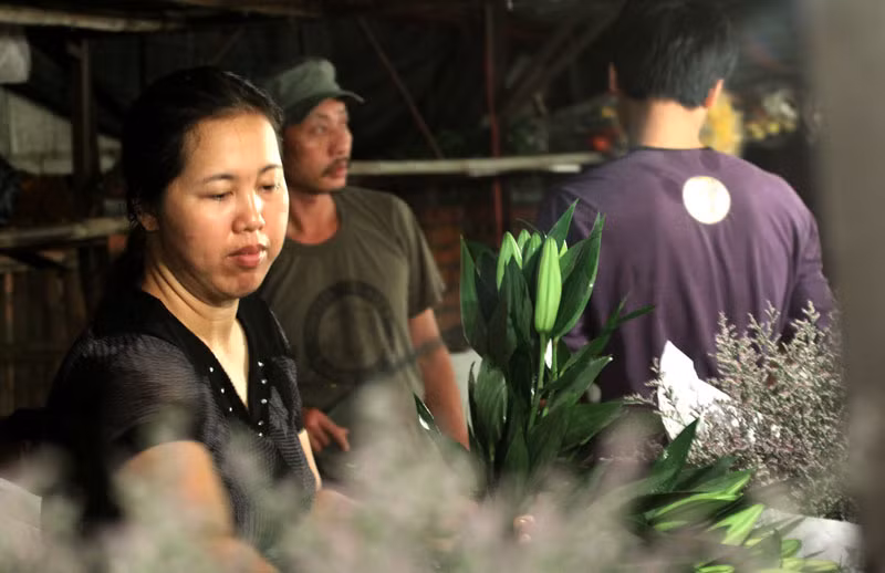 Còn bà chủ sạp hoa này thì đang xếp lại những cành hoa Ly cho gọn gàng.