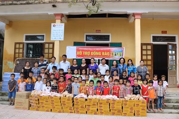 Gia đình ông Đặng Đình Hùng và ông Đinh Nho Lý đại diện cho hai con và một số bà con người Việt sinh sống làm ăn ở Hà Quốc trao quà cho giáo viên, học sinh trường tiểu học Hương Đô, mầm non Hương Trạch, Hương Đô.