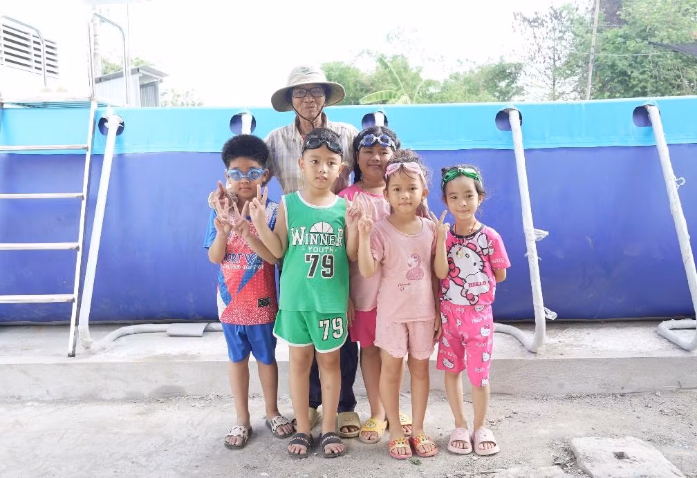 “Cô giáo” Sáu Thia cùng các học trò tại lớp bơi miễn phí bên chiếc hồ mới.