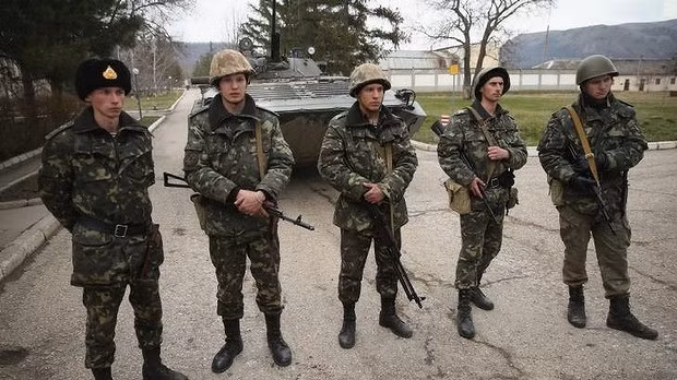 Lính và xe tăng Ukraine đứng bên trong cổng 1 căn cứ quân sự tại Crimea trong vòng vây của những người có vũ trang được cho là quân đội Nga hoặc tự vệ thân Nga. Lính và xe tăng Ukraine đứng bên trong cổng 1 căn cứ quân sự tại Crimea trong vòng vây của những người có vũ trang được cho là quân đội Nga hoặc tự vệ thân Nga.