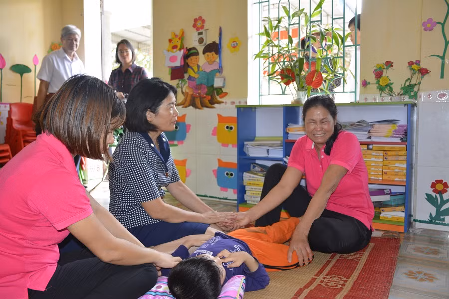 Một trong hai cô giáo trông bé Phát không giấu được cảm xúc khi đoàn kiểm tra của Bộ tới thăm (Ảnh: Minh Thu)