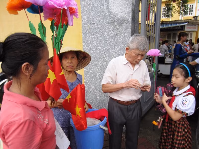 Chờ ông mua hoa và cờ chào đón lễ khai giảng