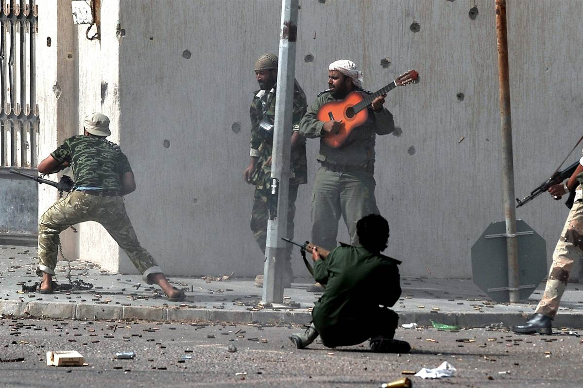 Quân nổi dậy bình thản chơi đàn giữa tiếng súng đạn chát chúa ở Sirte, Libya. Quân nổi dậy bình thản chơi đàn giữa tiếng súng đạn chát chúa ở Sirte, Libya.