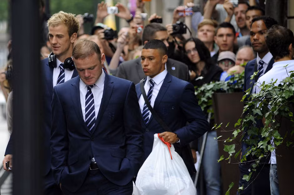 Wayne Rooney lộ rõ vẻ thất vọng khi cùng các đồng đội khác của đội tuyển Anh ra xe bus để tới sân bay về nước
