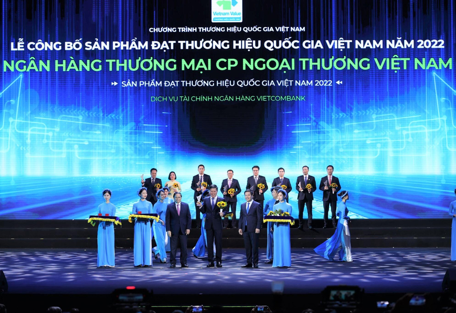 Thủ tướng Chính phủ Phạm Minh Chính (hàng đầu thứ 3 từ trái sang) trao Biểu trưng và đồng chí Nguyễn Hồng Diên - Bộ trưởng Bộ Công thương, Chủ tịch Hội đồng Thương hiệu quốc gia Việt Nam (hàng đầu thứ 2 từ phải sang) tặng hoa cho đồng chí Phạm Mạnh Thắng - Phó Tổng Giám đốc Vietcombank