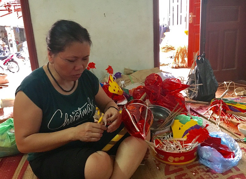 Bà Nguyễn Thị Tuyến đang hoàn thiện chiếc đèn con tôm. (Ảnh: Hồ Thu).