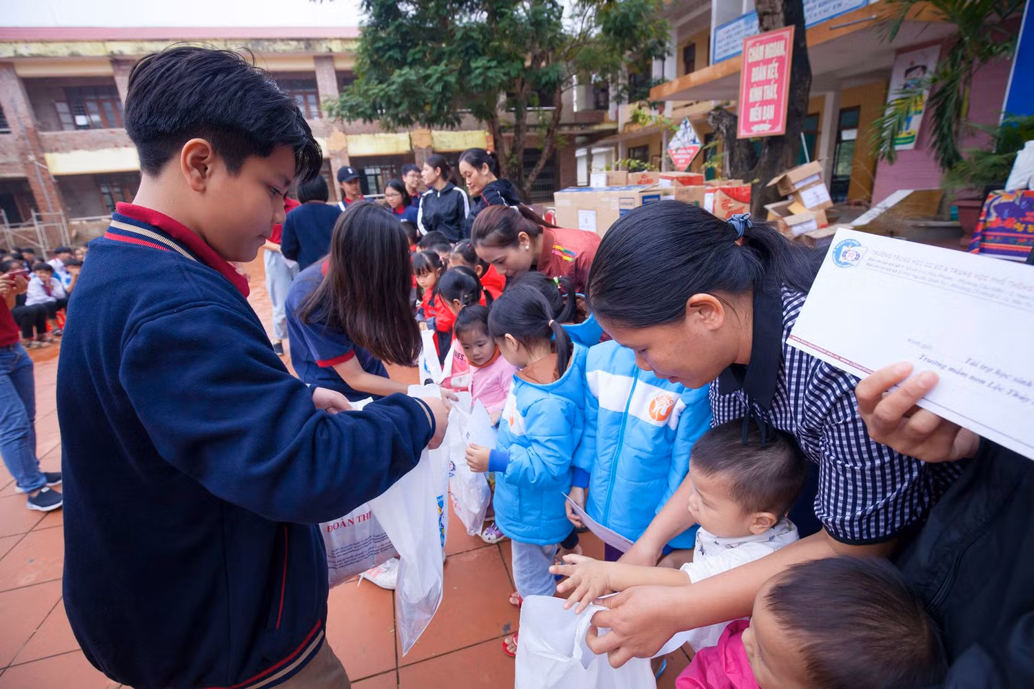 Các em học sinh Trường Trung học phổ thông Đoàn Thị Điểm tham gia trao quà cho trường mầm non tại xã Lộc Thủy, tỉnh Quảng Bình. Ảnh: Hữu Thành.